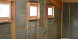 Exposed wall framing filled with soundproofing insulation batts