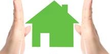 Hands framing a green house icon