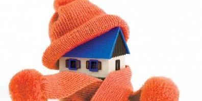 Toy house wrapped in a winter hat and orange scarf