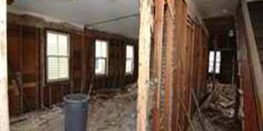 Interior room undergoing demolition with exposed wall studs
